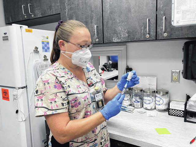 RHCC Nurse prepares vaccine for HACL Resident