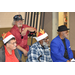 Four senior male residents, two wearing santa hats